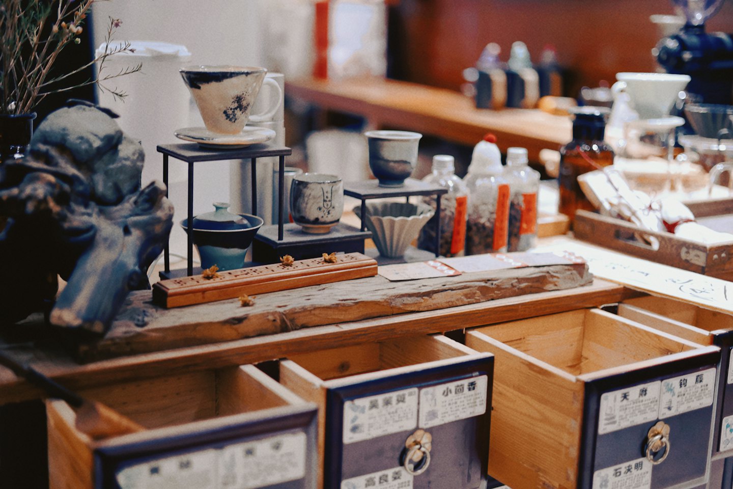 Artisanal East Asian tea ware and apothecary items on a wooden counter.