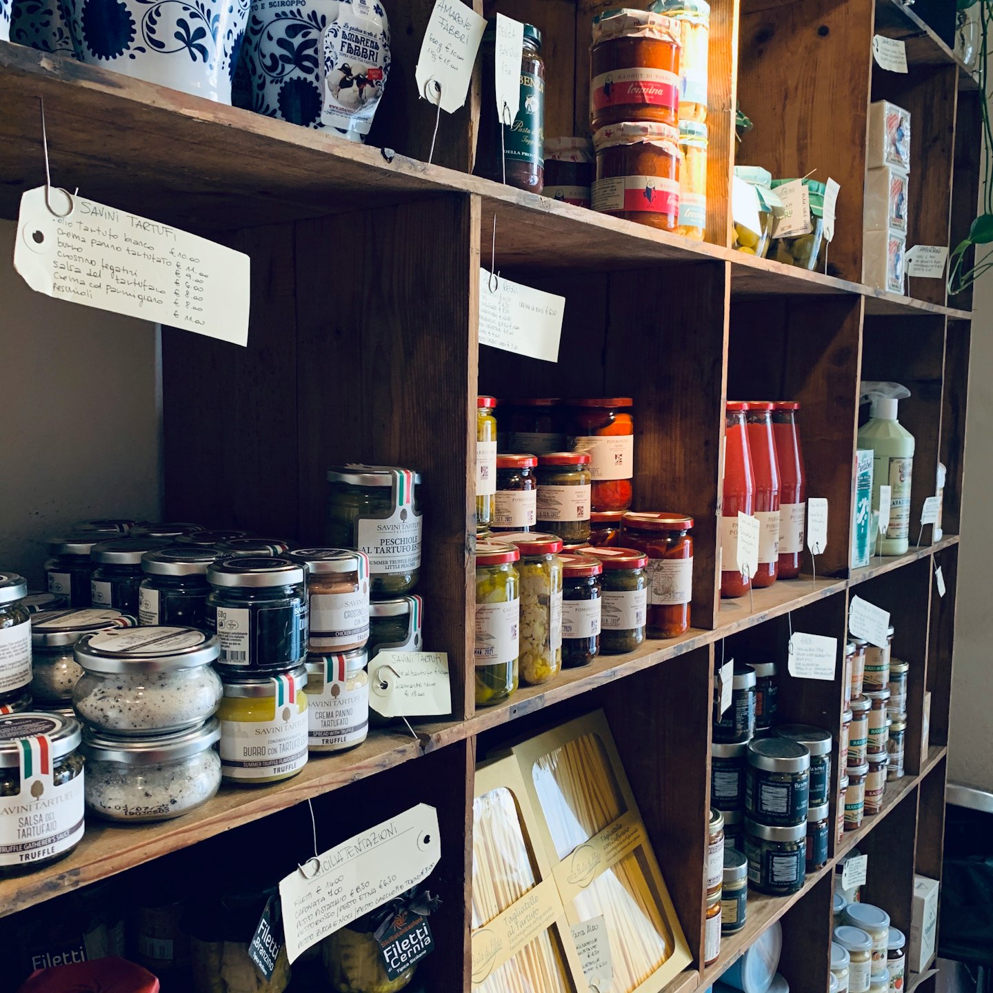 Rustic shelves stocked with artisanal Italian food products.